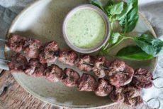 Grilled chicken hearts on skewer with green sauce on side